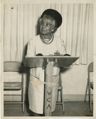 Photo of Mamie Fields at YWCA lectern with district map on back
