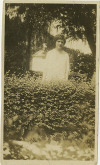 Woman Standing Behind Bushes