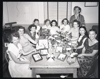 Group Photo of Women Around a Table With Ceramic Statuettes
