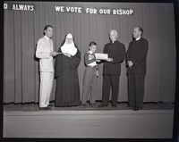 Bishop John Russell, a Nun, a Bishop, a Priest, a Man, and a Child Posing on a Stage