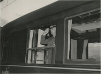 A military official saluting from the window of a train