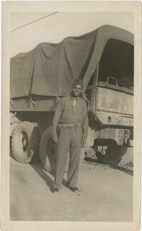 Photo of an African American Man Posing Next to a Military Truck