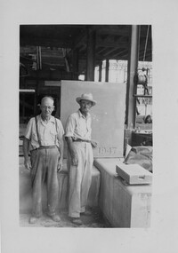 Two workmen by the 1947 Cornerstone for the Naval Hospital