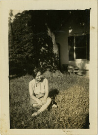 Woman sitting on grass in yard