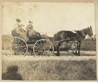 Two women and dog in wagon