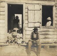 Group of children with one child in window frame of cabin