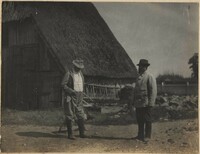 Two men in front of hay wagon in Altona