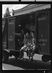 Men waving from the train boxcar in the 40 and 8 parade