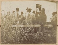 Group of laborers stand near white cabin
