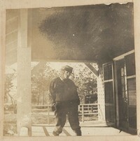 Man in mask on front porch of Main House