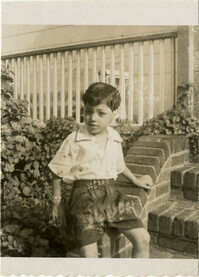 Unidentified boy seated on a porch step